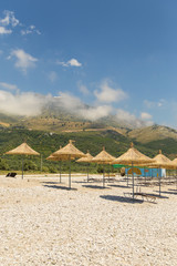 Umbrellas on the Borsh Beach in Albania. Stony beach on the Adriatic Sea.