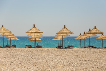 Umbrellas on the Borsh Beach in Albania. Stony beach on the Adriatic Sea.