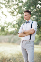 Portrait of a young handsome groom outdoors.
