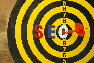 SEO Search Engine Optimization multi color logo alphabets ranking concept on dartboard background with red arrow hit center of target, SEO is one of online marketing business strategy to promote web