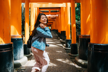 attractive female traveler running in the Torii