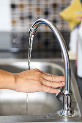Hand open or close a water tab in kitchen.