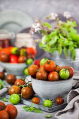 Fresh ripe cherry tomatoes in bowl on gray background