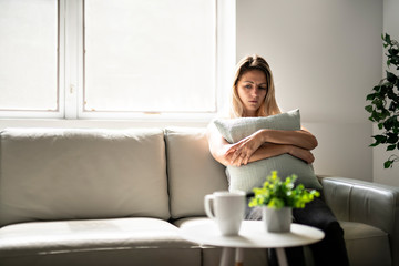 Unhappy lonely depressed woman at home living room