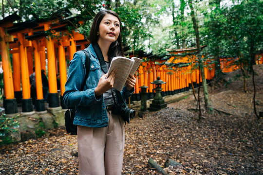 elegant asian photographer holding her guidebook