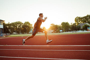 Obraz premium Fitness sportswoman running on sunrise track