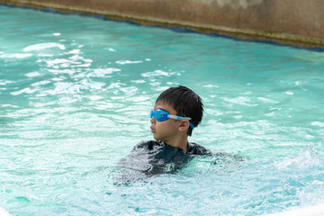 Asian boys are swimming in the pool.