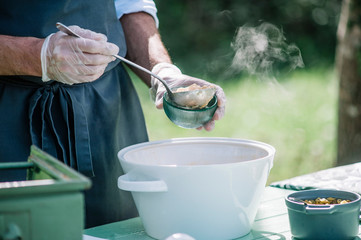 catering waiter serving food on white plate outdoors