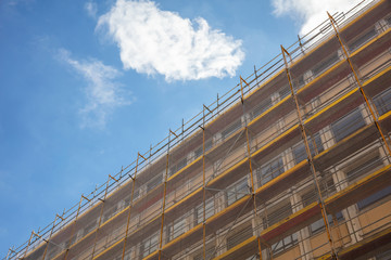 Building construction with scaffolding, blue sky background