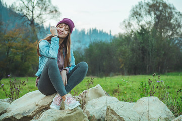 Portrait of young hipster girl enjoying an amazing view of mountains, pretty female traveler,...