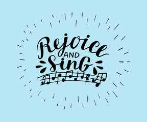 Hand lettering Rejoice and sing, made on blue background with notes.