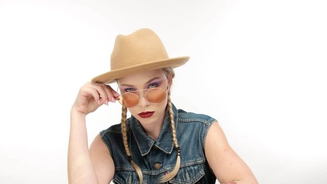 woman in cowboy style makes faces, touches hat and dancing