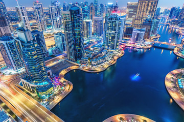 Scenic nighttime skyline of big modern city with illuminated skyscrapers. Aerial view of Dubai...