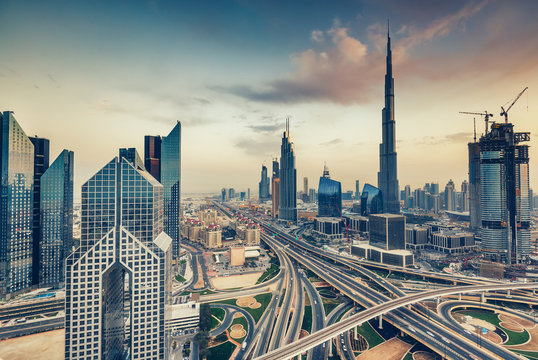 Aerial view over big highway interchange and skyscrapers in Dubai, UAE, at daytime. Scenic cityscape. Toned travel and architecture background.