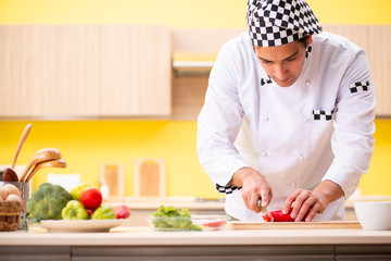 Young professional cook preparing salad at home