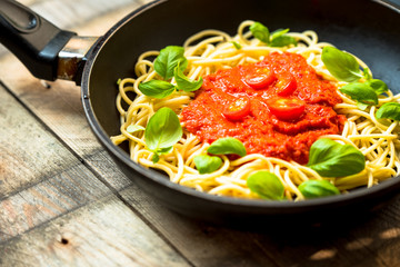 pasta with herbs, basil and tomato sauce served in a frying pan