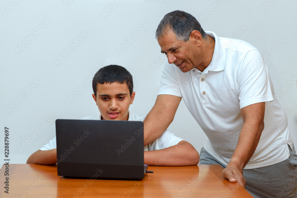 Wall mural people using new, exciting technology elearning technology. senior father and teenage son using lapt