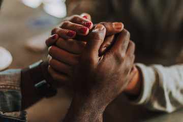 Holding hands. Laconic photo of young man and woman holding hands and looking cute