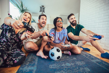Group of friends play video games together.