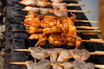 Grilled fried seafood on skewers on metal grid