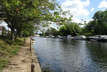 Fototapeta na wymiar Boats and sun on the river at Thorpe River Green, Norwich, Norfolk, England, UK