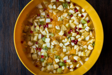 Homemade Healthy Organic Fruit Salad in Yellow Plastic Bowl.
