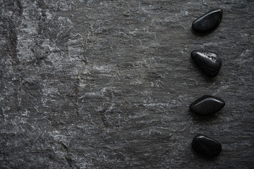 Dark grey black slate stone background with zen basalt stones in luxury asian spa