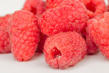 ripe juicy raspberries on white table