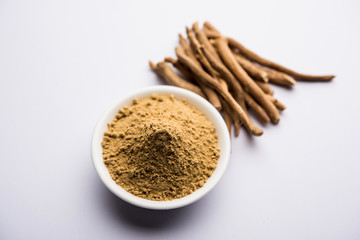 Ashwagandha / Aswaganda OR Indian Ginseng is an Ayurveda medicine in stem and powder form. Isolated on plain background. selective focus