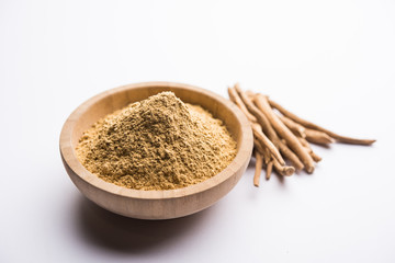 Ashwagandha / Aswaganda OR Indian Ginseng is an Ayurveda medicine in stem and powder form. Isolated on plain background. selective focus