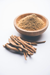 Ashwagandha / Aswaganda OR Indian Ginseng is an Ayurveda medicine in stem and powder form. Isolated on plain background. selective focus