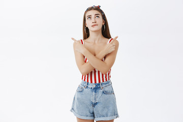 Stylish girl cannot device which party attend. Unsure silly attractive woman in pin-up outfit...