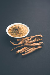 Ashwagandha / Aswaganda OR Indian Ginseng is an Ayurveda medicine in stem and powder form. Isolated on plain background. selective focus