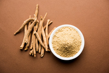 Ashwagandha / Aswaganda OR Indian Ginseng is an Ayurveda medicine in stem and powder form. Isolated on plain background. selective focus