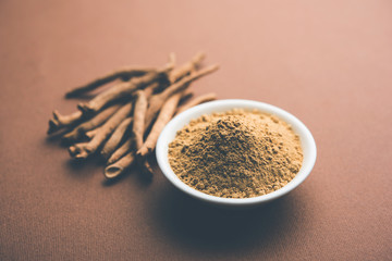 Ashwagandha / Aswaganda OR Indian Ginseng is an Ayurveda medicine in stem and powder form. Isolated on plain background. selective focus