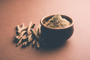 Ashwagandha / Aswaganda OR Indian Ginseng is an Ayurveda medicine in stem and powder form. Isolated on plain background. selective focus