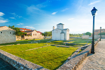 Croatia, Dalmatia, Nin, medieval church of Holy Cross from 9th century and archaeological site in historic center of town of Nin, summer day, urban landscape