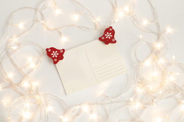 Blank postcard on white background surrounded by holiday lighs