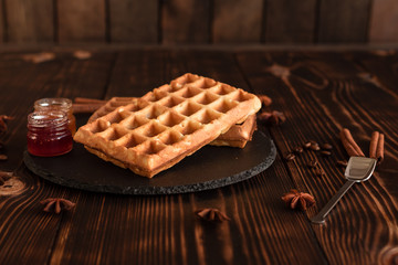 Tasty fresh Vienna wafers, jam and cup of coffee on a dark wooden background
