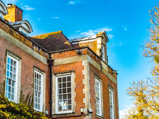 Windows and roof of red brick and stone mansion