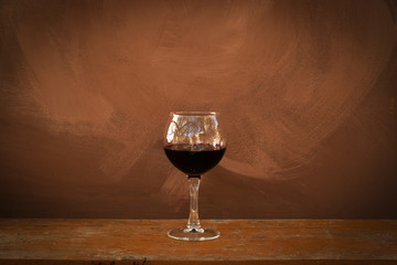 Red wine in wineglass on a brown background
