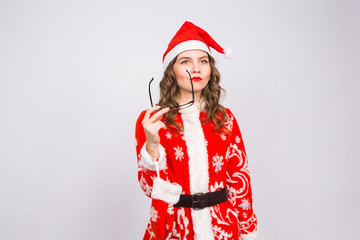 Christmas, holidays and people concept - young woman in santa suit took off glasses on white background with copy space