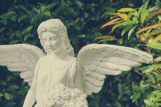 Beautiful ange statue in green garden, valentine romantic day - vintage tone