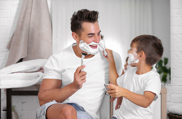 Father and son having fun while shaving in bathroom