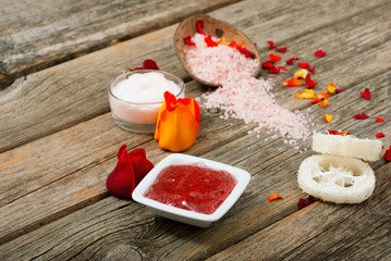 facial mask and moisturizer with roses on weathered wooden