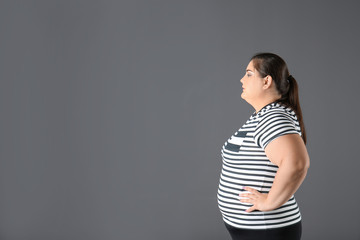 Portrait of overweight woman and space for text on gray background