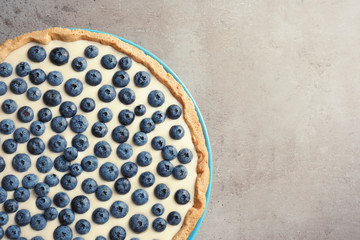 Tasty blueberry cake on gray background, top view with space for text