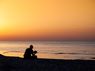 Obraz na płótnie Canvas Im Urlaub ein Buch am Strand lesen