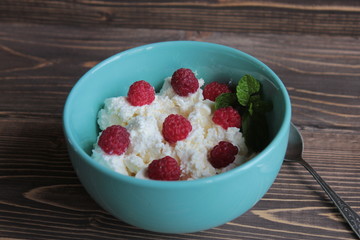 Cottage cheese with raspberries in a blue bowl.