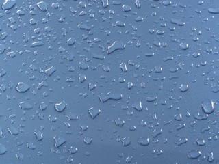 Blue water drops, detail of blue surface water-repellent on glass for background.